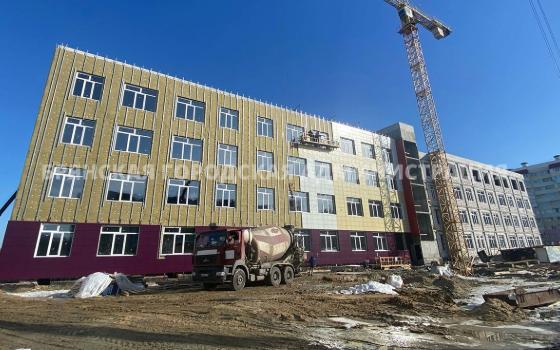 Рабочие облицовывают фасад новой школы в Брянске