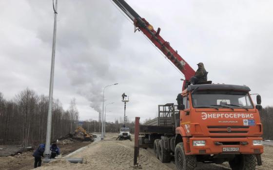 Рабочие монтируют освещение на новой дороге на подъезде к Фокино