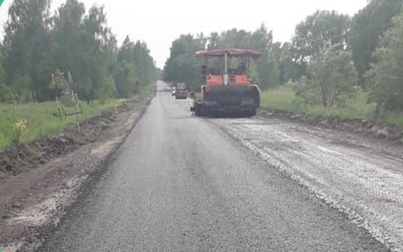 Подрядчик укладывает выравнивающий слой асфальта на трассе в Комаричском районе